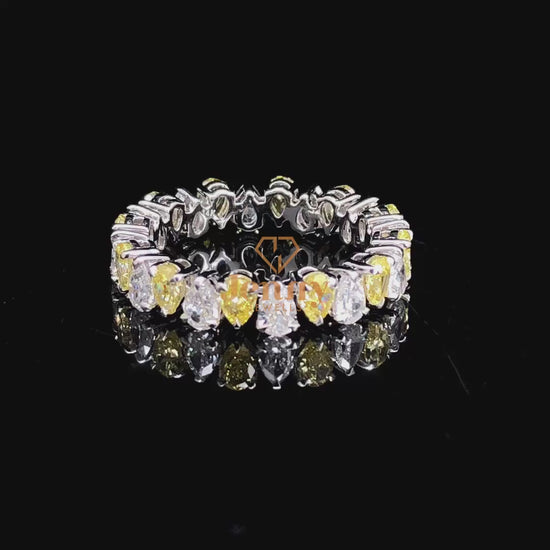 Pear-shaped diamond eternity ring with a mix of white and fancy yellow diamonds, set in white, yellow, or rose gold. A bold and elegant statement piece.
